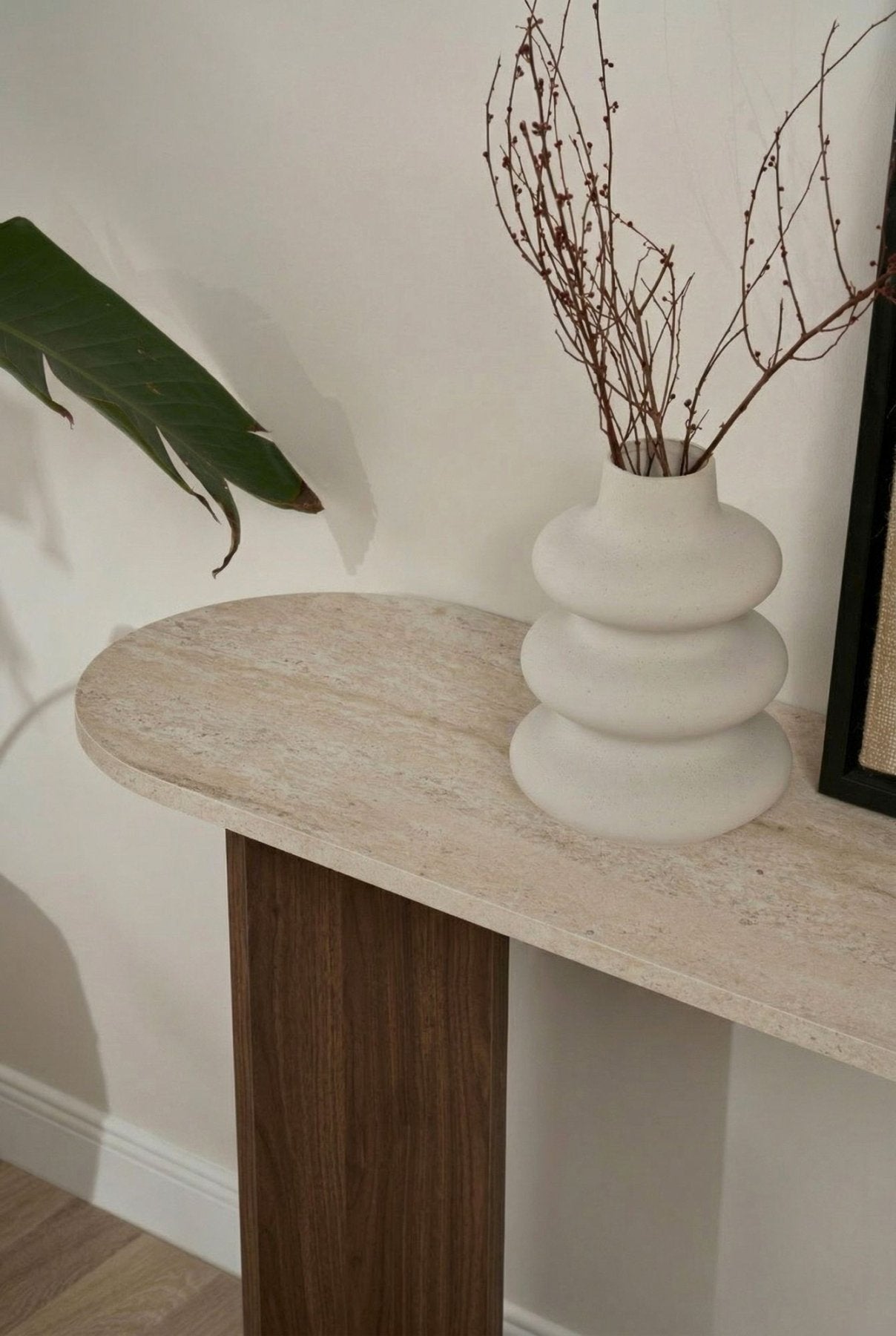 Moderner ovaler Beistelltisch mit einer Platte in Travertin-Optik und einem Walnuss-Melamin-Untergestell. Stilvolles minimalistisches Design.